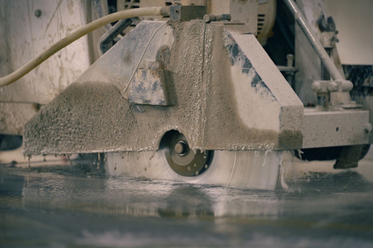 Industrial concrete saw cutting into a concrete floor slab
